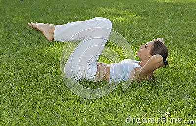 Sporty girl exercising on meadow against the sky Stock Photo