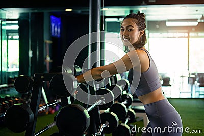woman pose with barbell in fitness gym at relaxing time Stock Photo