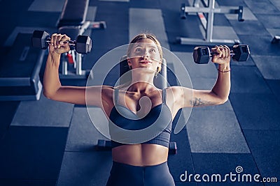 Sporty girl workout with dumbell in gym Stock Photo