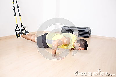 Sporty man makes legs suspension training Stock Photo