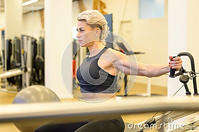 Sporty middle-aged woman working out in a gym Stock Photo