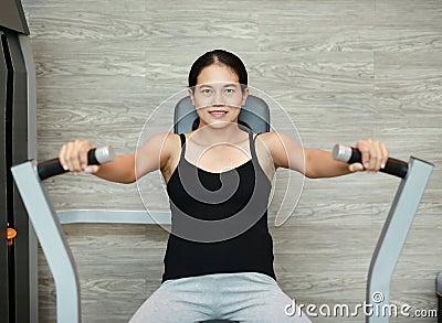 Sporty pregnant woman exercising in fitness room with smiling and looking at camera Stock Photo
