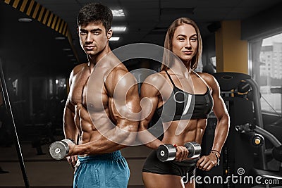 Sporty couple showing muscle and workout in gym. Muscular man and wowan Stock Photo