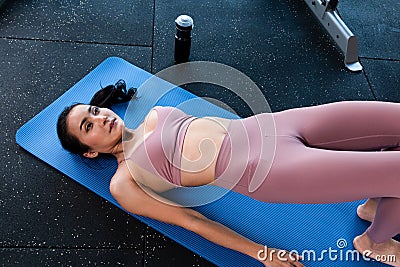 Sporty woman doing exercises doing Bridge position on blue mat. Healthy beautiful women doing glute Bridge exercise pelvic lift a Stock Photo