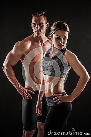 Sporty young couple posing on black background Stock Photo