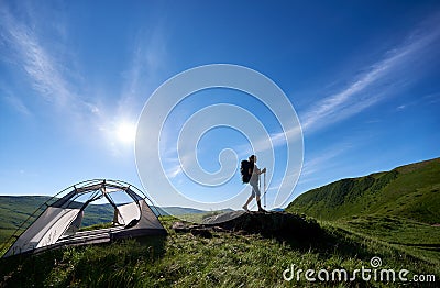 Silhouette of woman climber near camping against blue sky in the morning Stock Photo