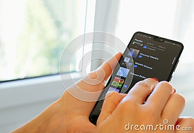 Spotify music app hand smartphone playlist scrolling Editorial Stock Photo