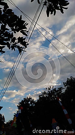 Spots of clouds mixed with the blue sky, adorn the scenery under the shady trees Stock Photo