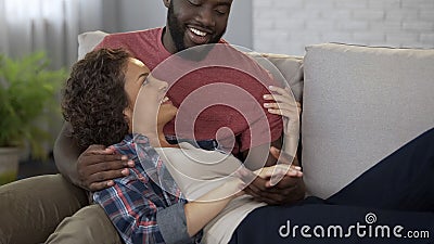 Spouse telling his wife funny stories, happy people enjoying relax at home Stock Photo