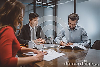 Spouses writing a divorce request with their lawyer Stock Photo