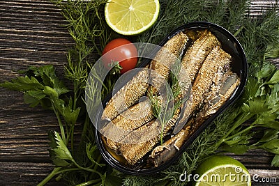 Sprats in a can, fresh preserve gastronomy gourmet nutritious delicious dill lime lunch on wooden background Stock Photo