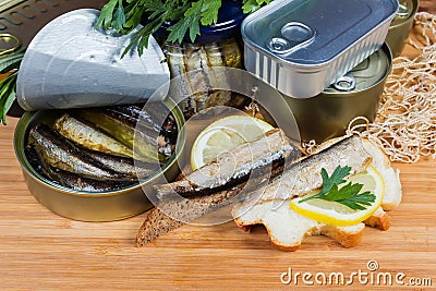 Sprats in open tin can, open sandwiches against other cans Stock Photo