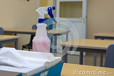 A spray bottle and paper towels on an office or school desk for cleaning and sanitization concepts for COVID-19 coronavirus Stock Photo
