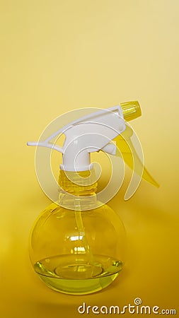 Spray bottle on yellow background. Portable pressure water sprayer pump Stock Photo