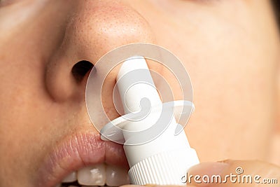 Spray for a nose in a girl`s nose, nose drops, gri n and colds, cannot breathe, nasal congestion Stock Photo