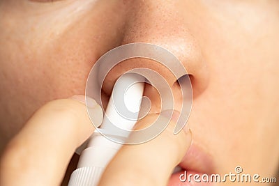 Spray for a nose in a girl`s nose, nose drops, gri n and colds, cannot breathe, nasal congestion Stock Photo