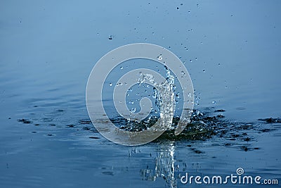 Spray of water from a thrown stone into the water Stock Photo