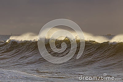Spraying breaking waves at sunset Stock Photo