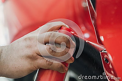 spraying grease on the car door mechanism at shallow depth of field Stock Photo