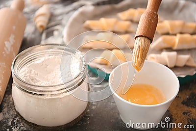 Spreading egg yolk on croissants Stock Photo