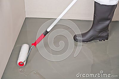 Spreading self leveling compound with roller Stock Photo