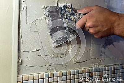 Spreading of tile adhesive with a trowel. Stock Photo