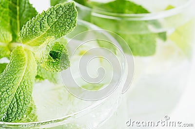 Sprig fresh mint on summer cool lemonade in glasses with lime, ice, straw, closeup, blur. Stock Photo