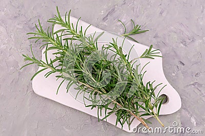 Sprigs of rosemary on a wooden board. Flat lei. Stock Photo