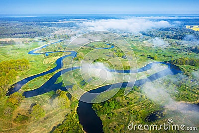 Spring aerial nature background. River landscape from above. Drone view of curved river on green meadow through white clouds on Stock Photo