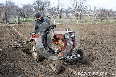 Spring agricultural work. Farmer on a tractor in the field Editorial Stock Photo