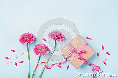 Spring composition with pink flowers and gift box on blue table top view. Greeting card for Birthday, Woman or Mothers Day. Stock Photo