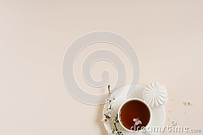 Spring concept. Cup of morning black tea with sweets marshmallows on beige background with sprig of blooming apple tree with copy Stock Photo