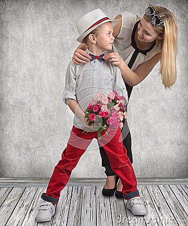 Small son gives his beloved mother a beautiful bouquet of pink roses . Spring, concept of family vacation. Women`s day,mother`s da Stock Photo