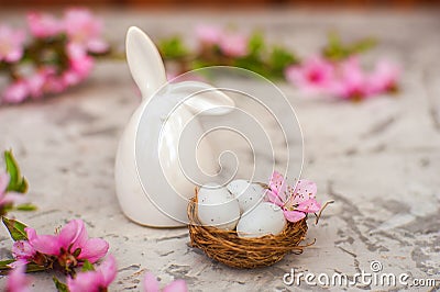 Spring conceptual photo with flowers. Flat lay blooming tree, easter eggs. The tree blooms pink and the eggs in the nest and copy Stock Photo