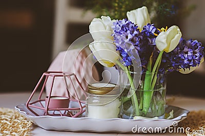 spring decorations at home on the table in modern scandinavian style with flowers and aromatic candles Stock Photo
