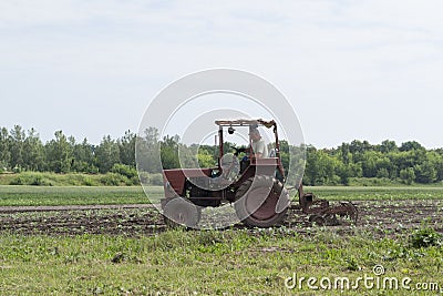 Spring field work. Ukraine. A man on a tractor cultivates the land for the sowing of agrotechnical plants. Stock Photo