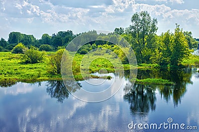 Spring landscape with river and clouds on the blue sky Stock Photo