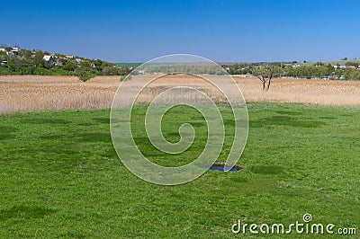 Spring landscape with small round lake in a meadow Stock Photo