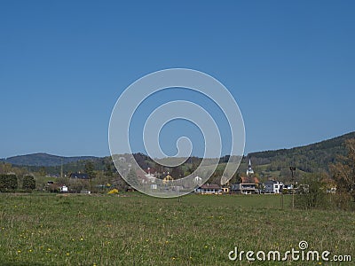 Spring landscape with view on village Cvikov in Lusitian mountains with old and modern houses and lush green grass Stock Photo