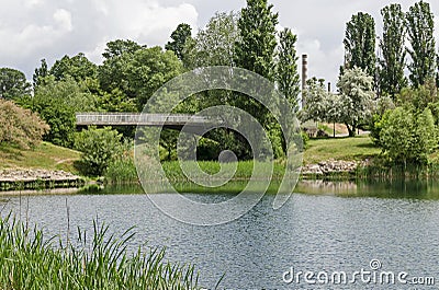 Spring panorama of a part of residential district, bridge and Thermoelectric power plant neighborhood along a lake with green tree Stock Photo