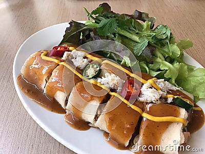 Spring roll with tamarind sauce topped with crab and mustard and chili Stock Photo