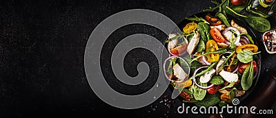 Spring salad with spinach, grilled chicken, cherry tomatoes, arugula, corn salad and red onion. Healthy food concept. Black stone Stock Photo