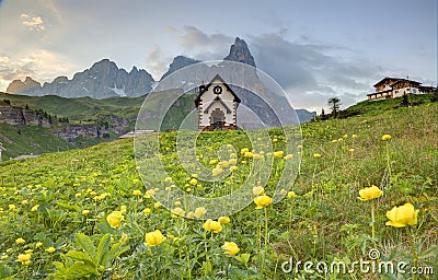 Spring scenery of Dolomites with view of a lovely church at the foothills of rugged mountain peaks Stock Photo
