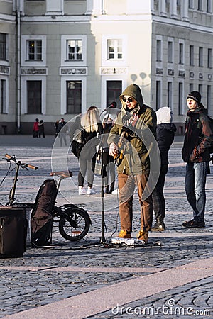 In the spring on the street of the city singer performed with the accompaniment of electric tools Editorial Stock Photo