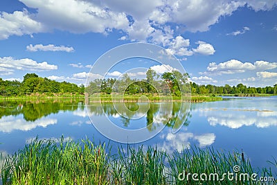 Spring summer landscape blue sky clouds river pond green trees Stock Photo