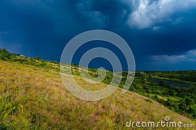 Spring thunderstorm in countryside. Dark blue cloudscape Stock Photo