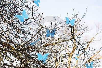 Spring tree and colorful artificial blue butterflies Stock Photo