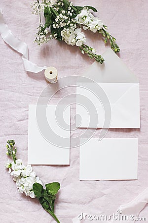 Spring, wedding stationery mockup scene. Bouquet of baby`s breath Gypsophila and matthiola flowers on pink linen Stock Photo