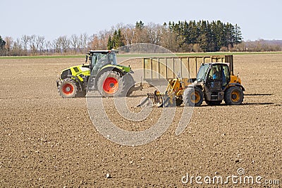 Spring work at farm. Farmer in tractor preparing the field for sowing. Farmer land and traktor Stock Photo