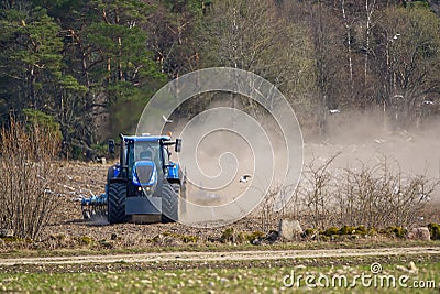 Spring work at farm. Farmer in tractor preparing the field for sowing. Farmer land and traktor Stock Photo